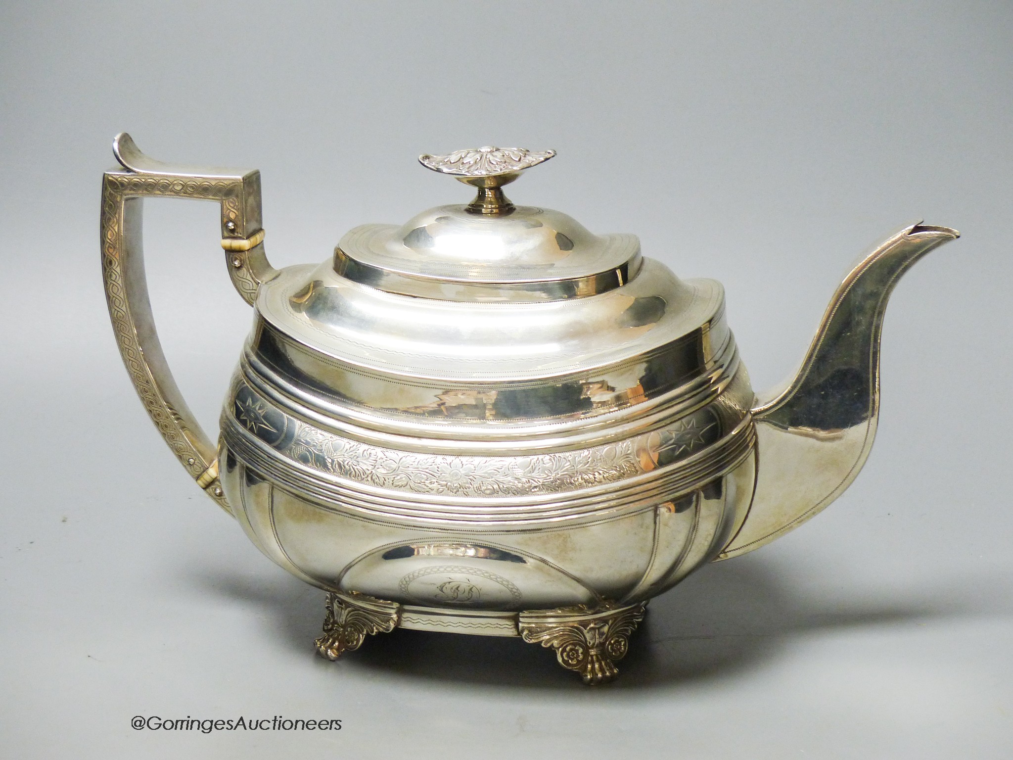 A George IV silver shaped oval teapot, by Naphthali Hart, London, 1824, with reeded and floral bands, on winged paw feet, gross 26oz.